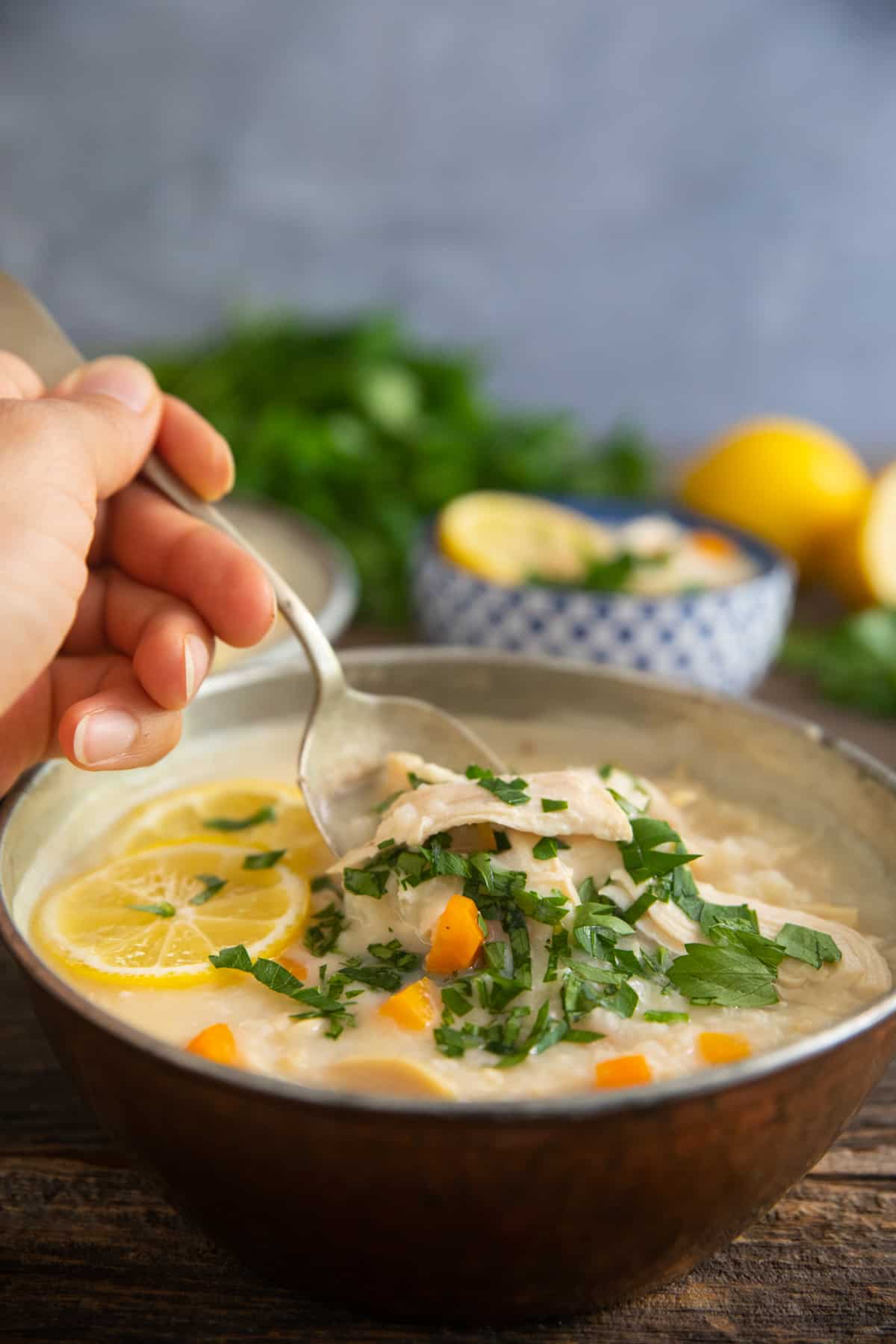 A spoon serving some Greek lemon chicken soup. 