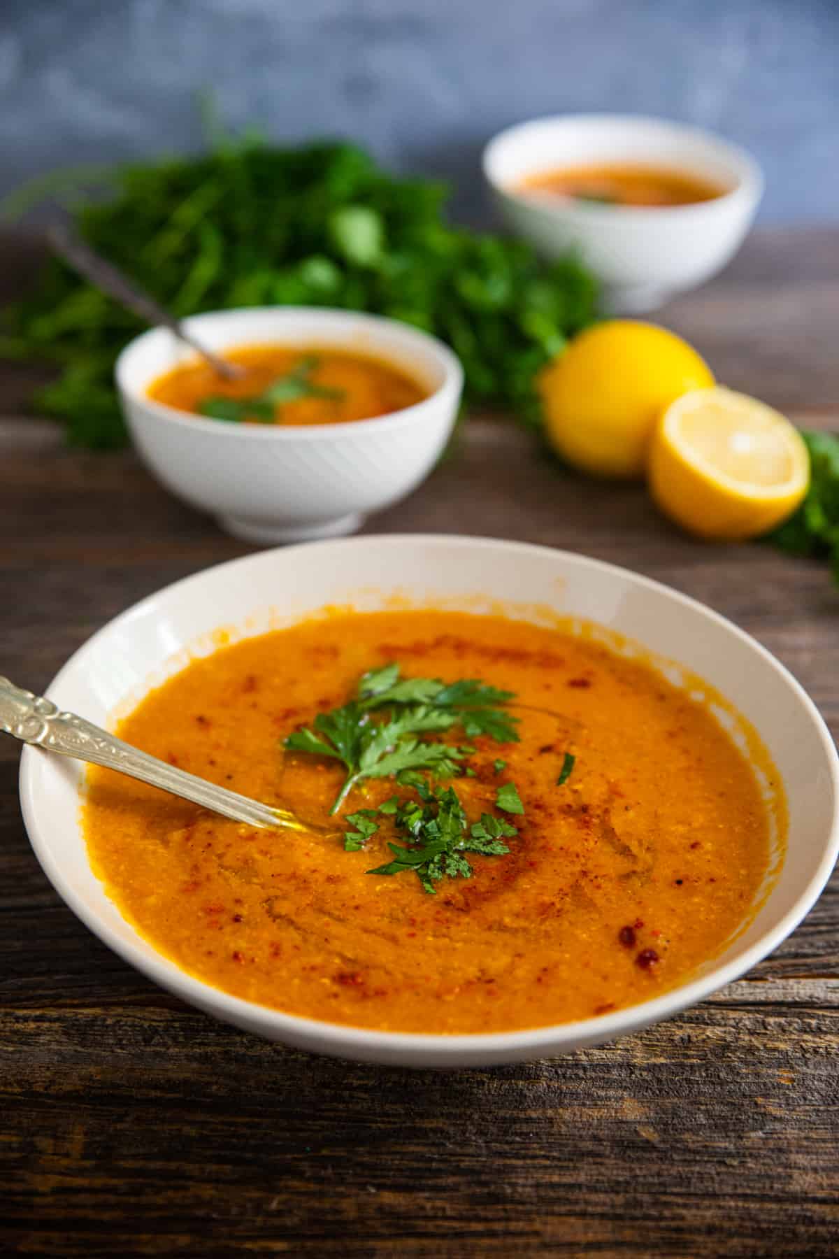 front shot of a bowl of soup topped with herbs and pepper.