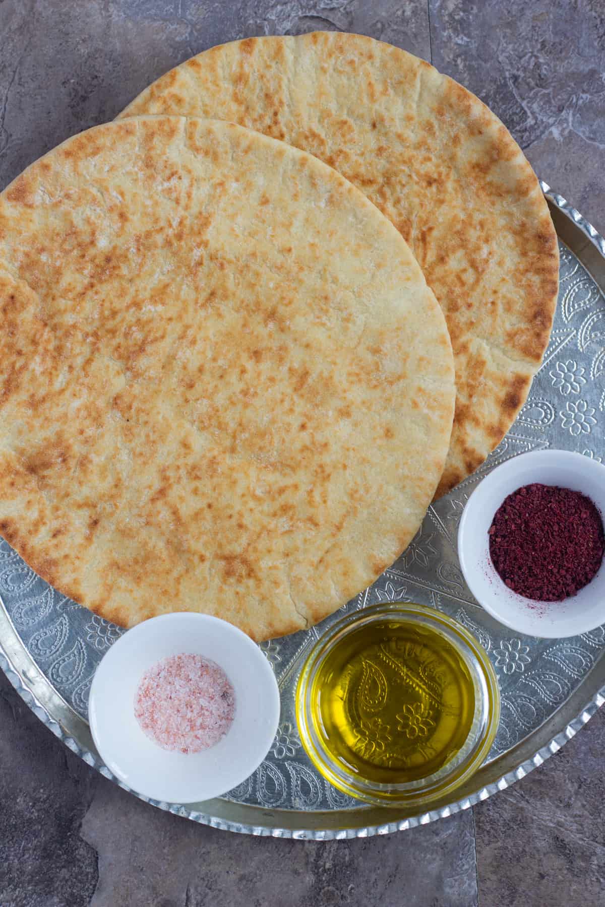 To make homemade pita chips you need pita bread, sumac, salt and olive oil. 