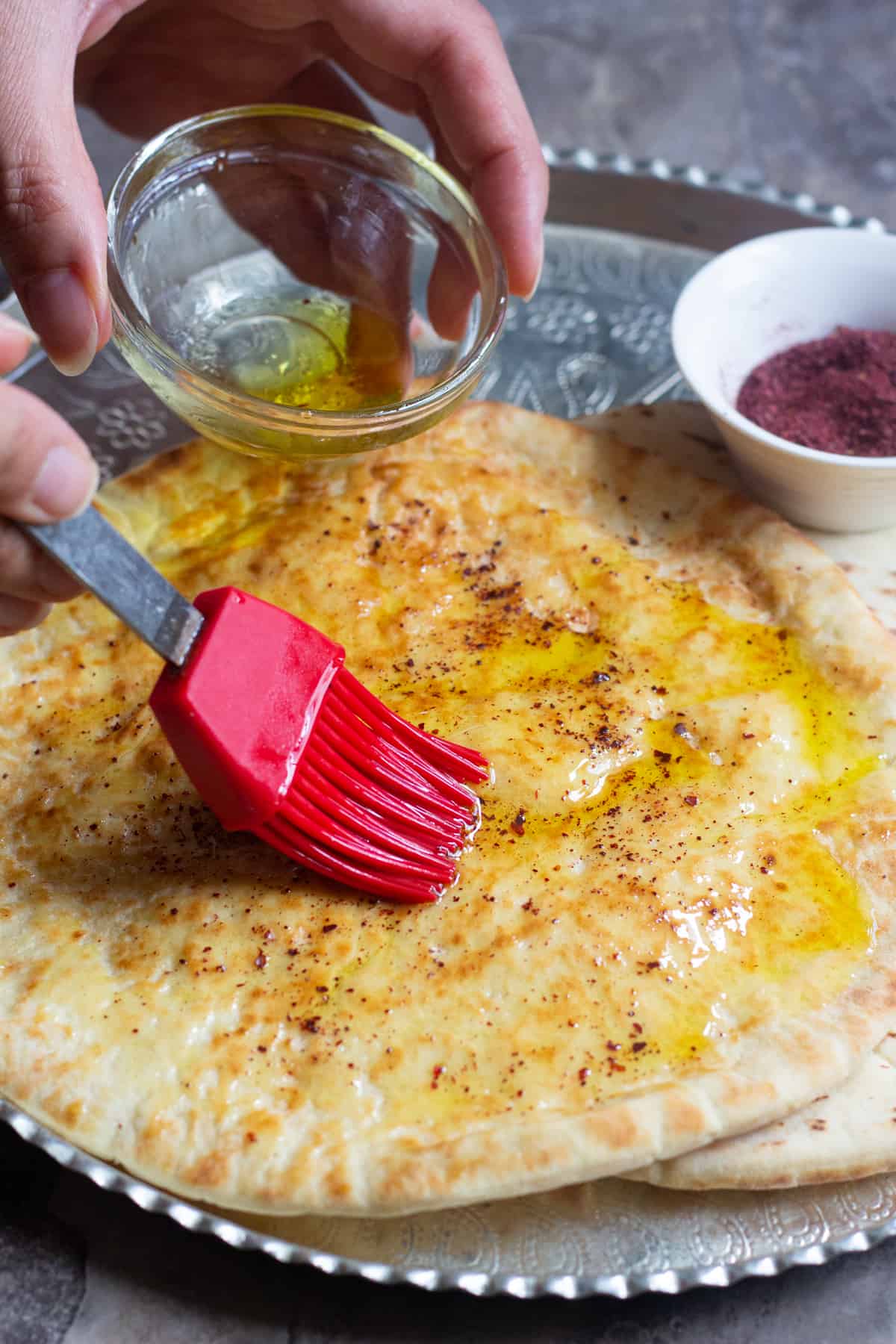 Brush the pita with olive oil and top with salt and sumac. 