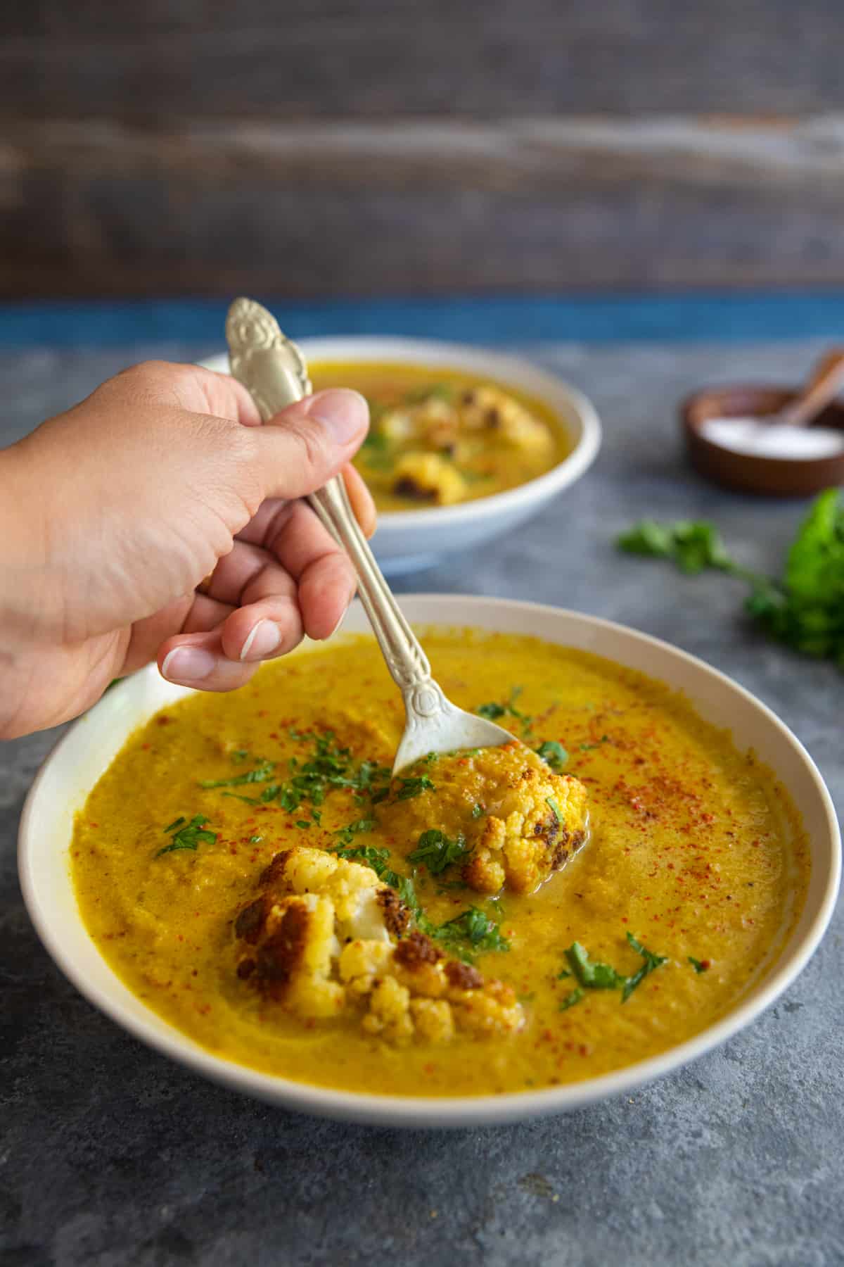 front shot of roasted cauliflower soup with a spoon. 