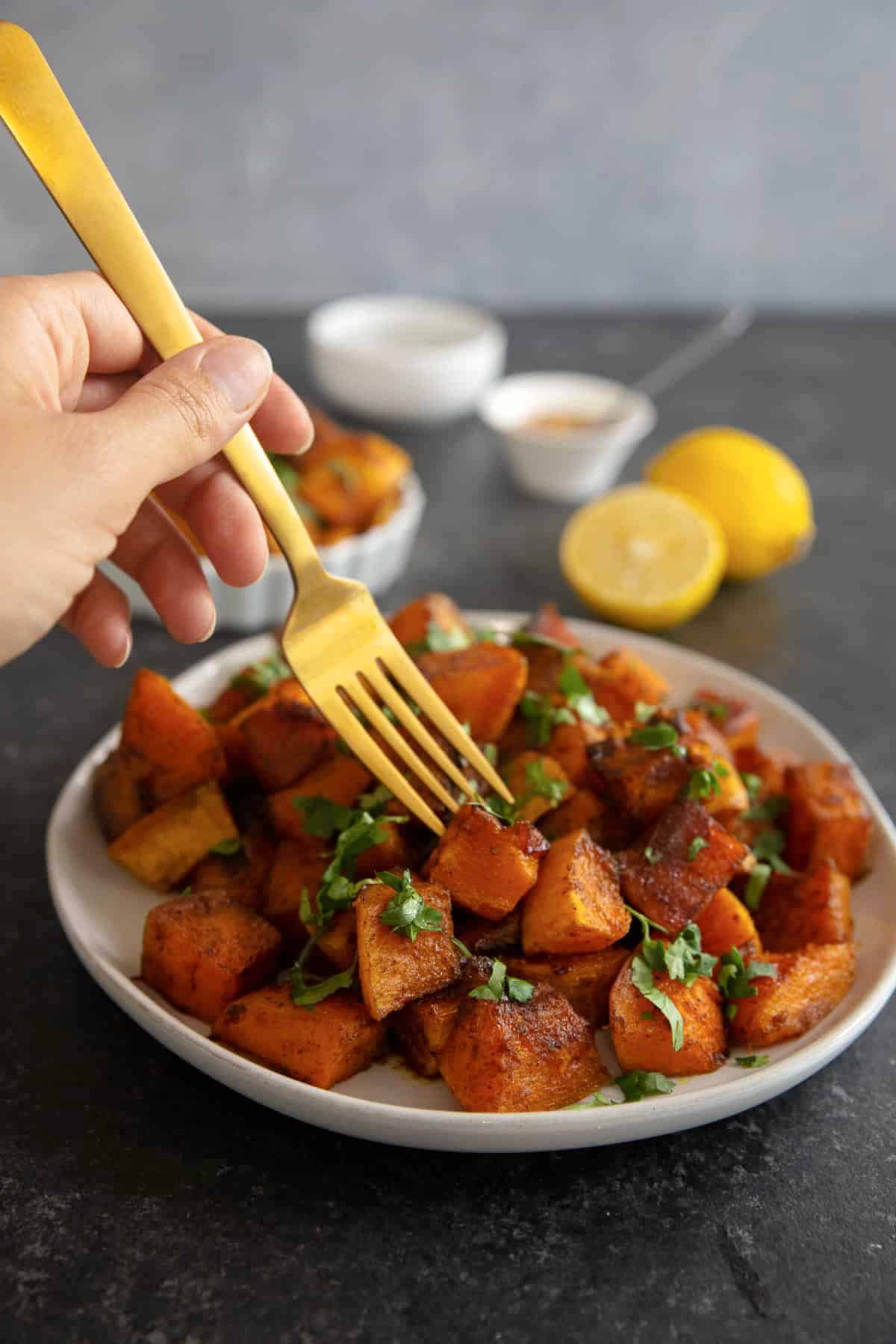 front shot of roasted butternut squash with a golden fork.