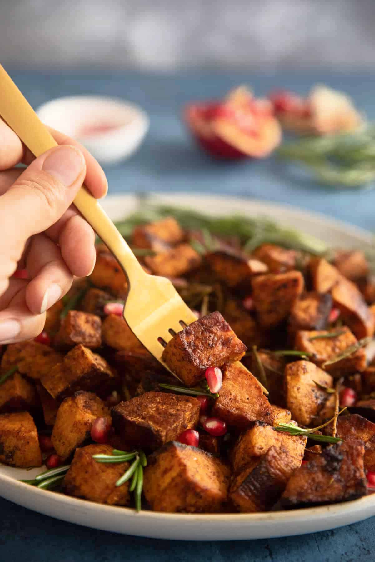 Caramelized Roasted Sweet Potatoes Front shot of oven roasted sweet potatoes with a golden fork.