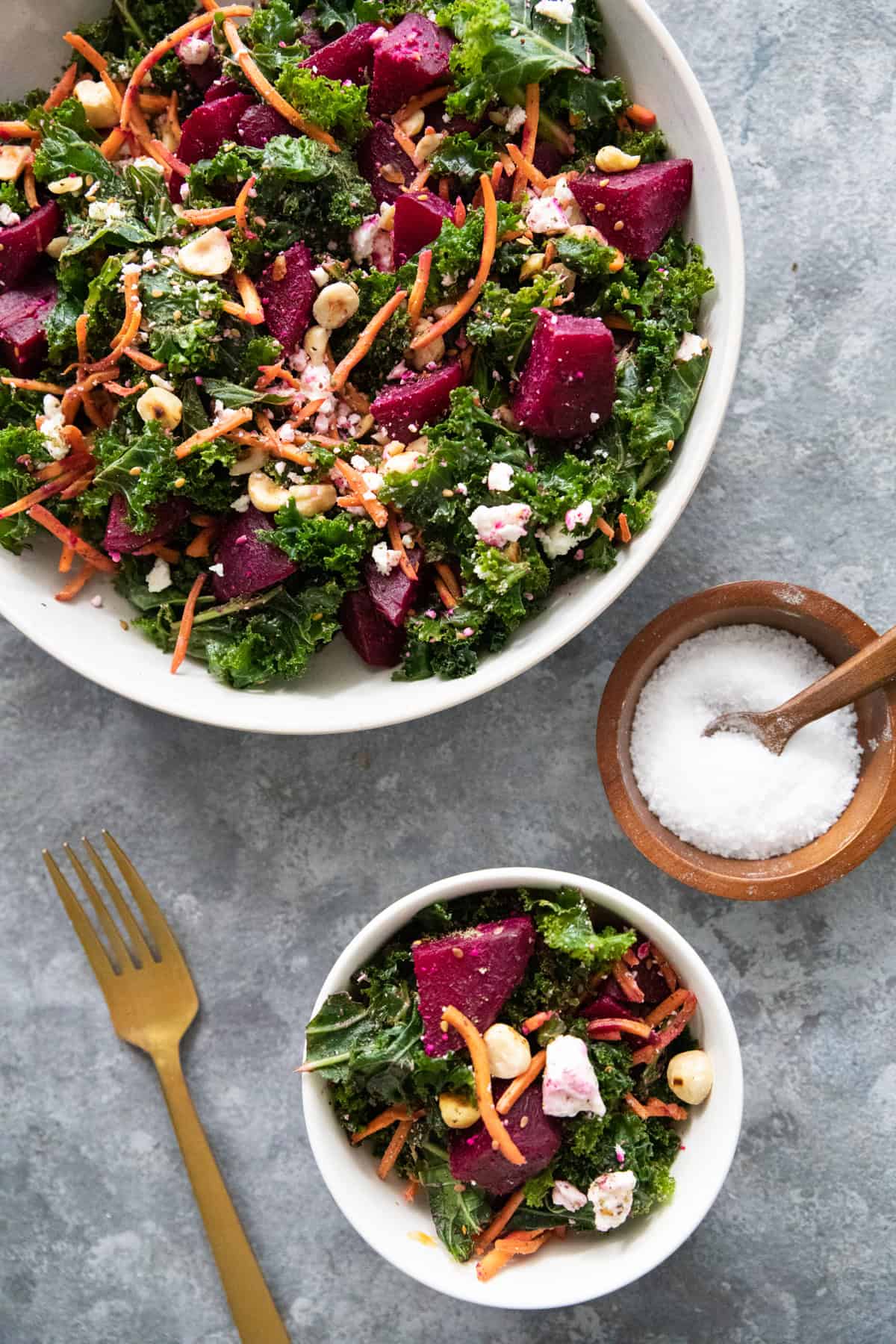 Two bowls of beet salad on a grey surface. 