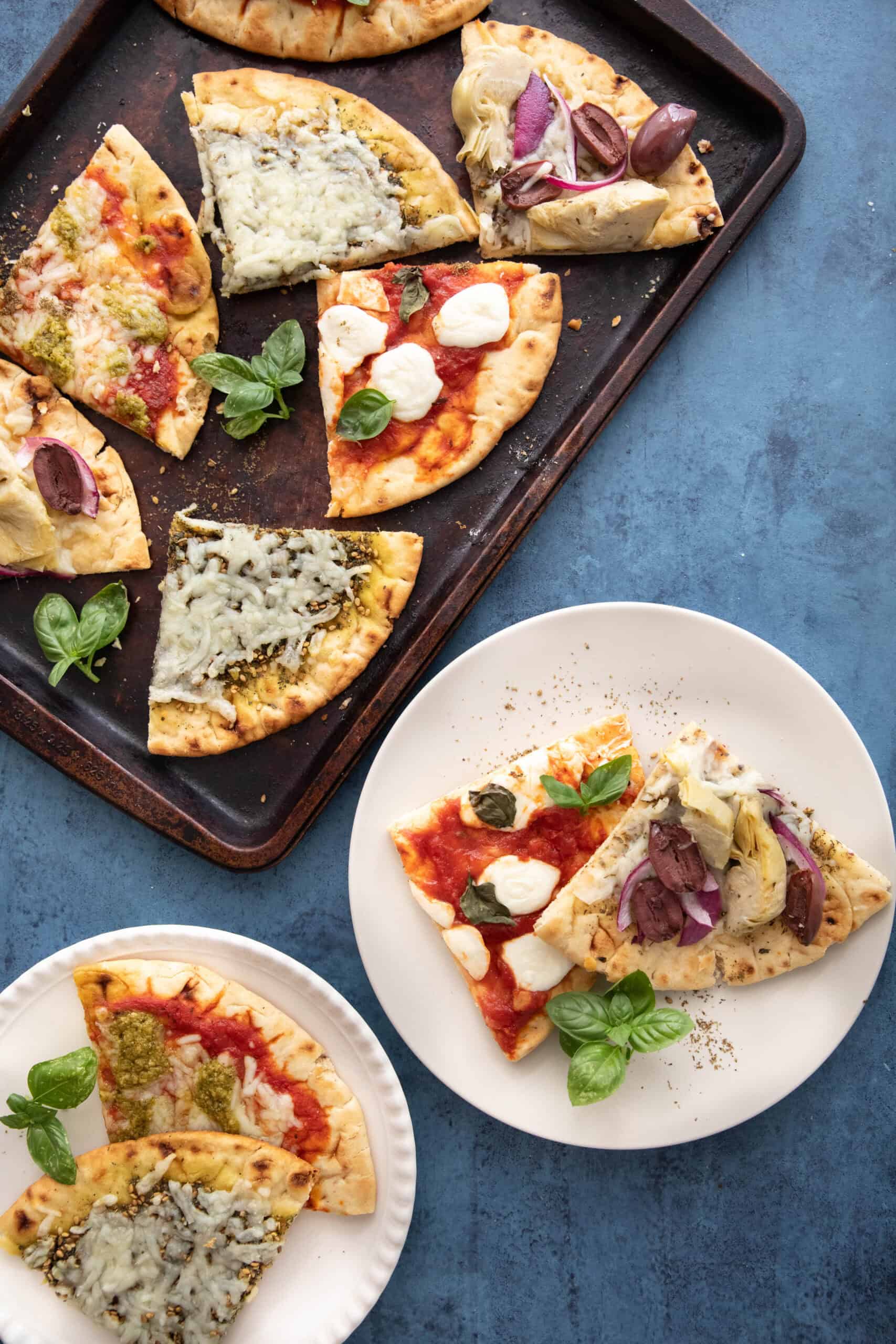 A selection of flatbread pizzas on platters and plates.