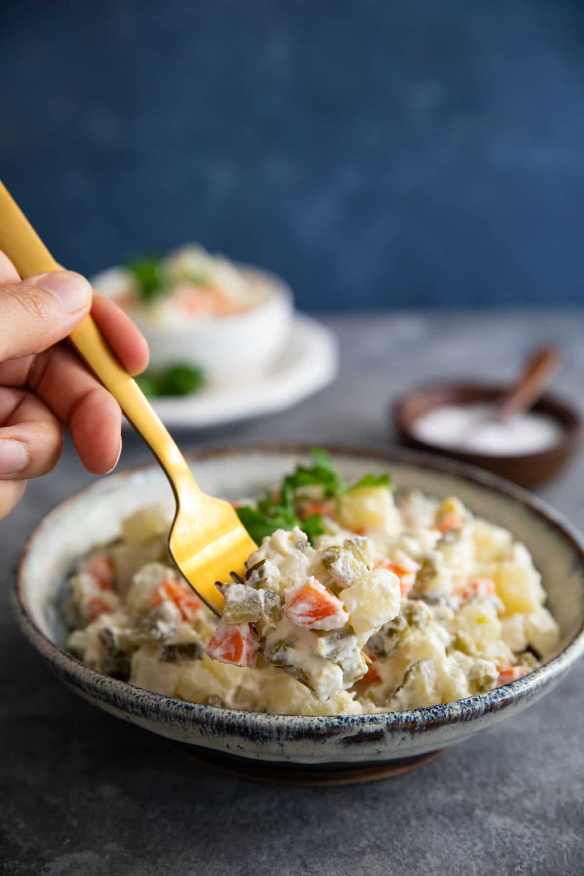 Front shot of a fork grabbing some Russian potato salad.