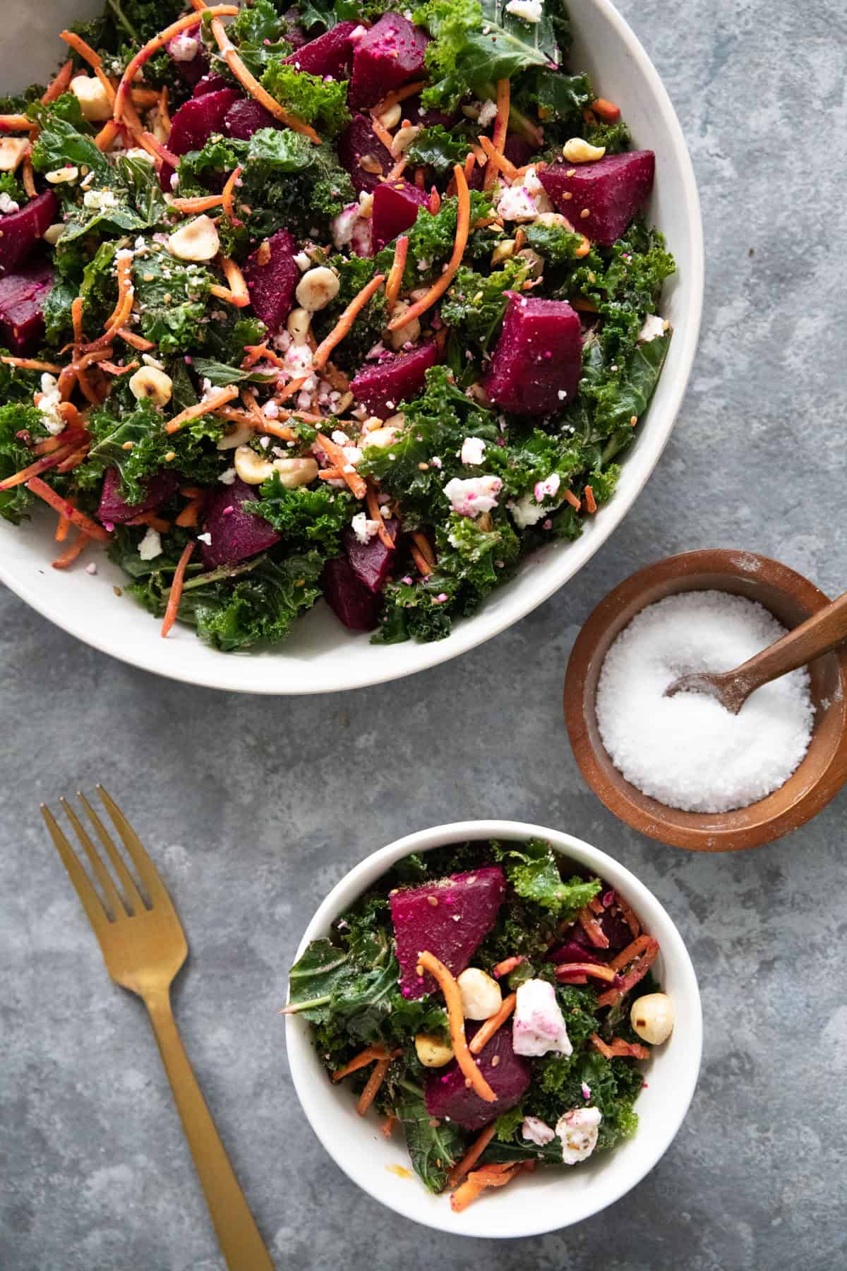 Two bowls of beet salad on a grey surface. 