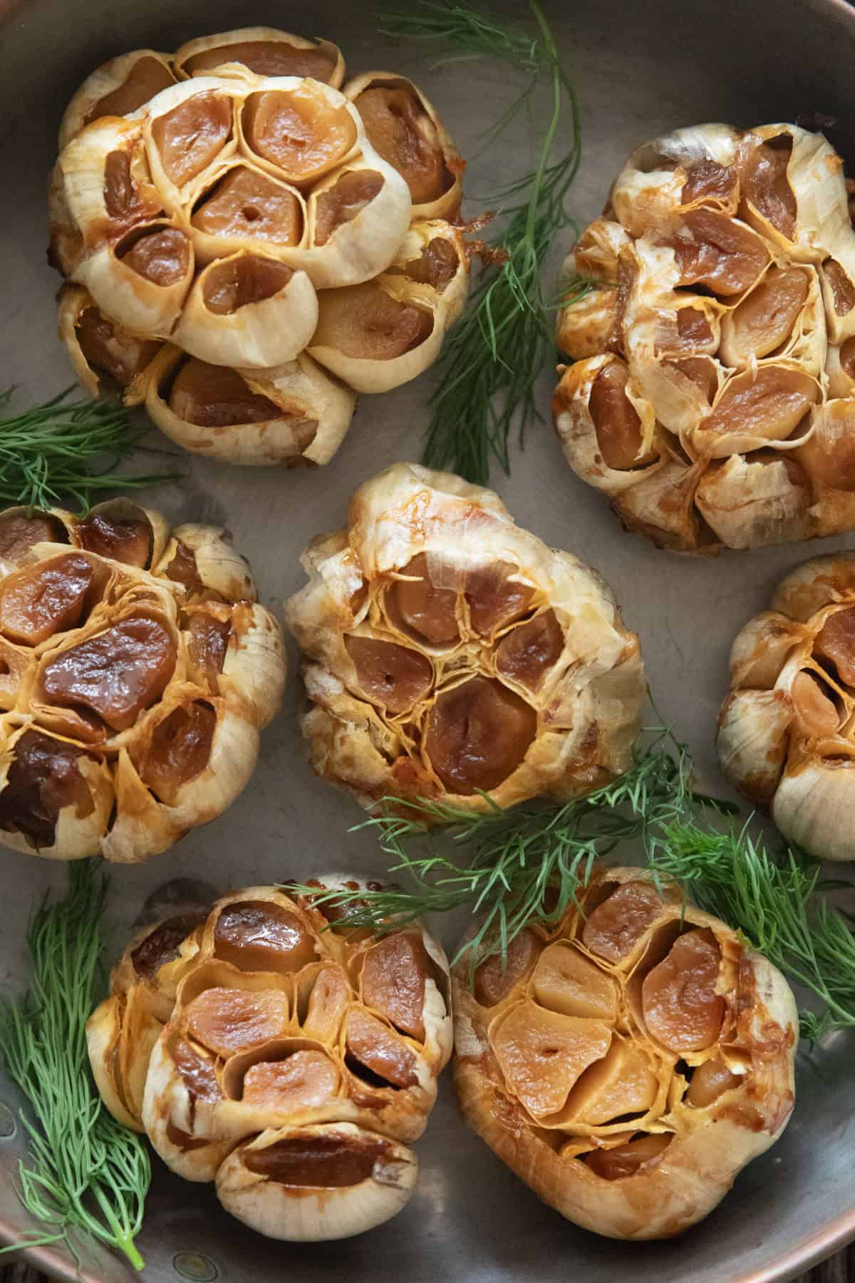 roasted garlic bulbs in a pan.