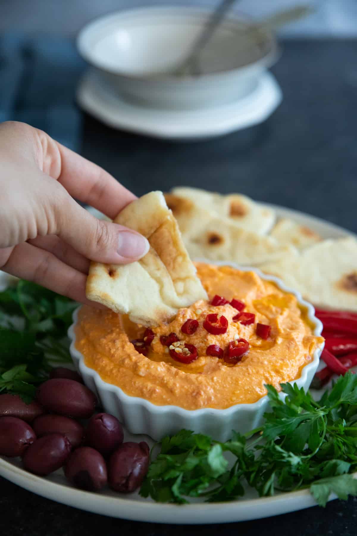 Dip pita bread in tirokafteri. 