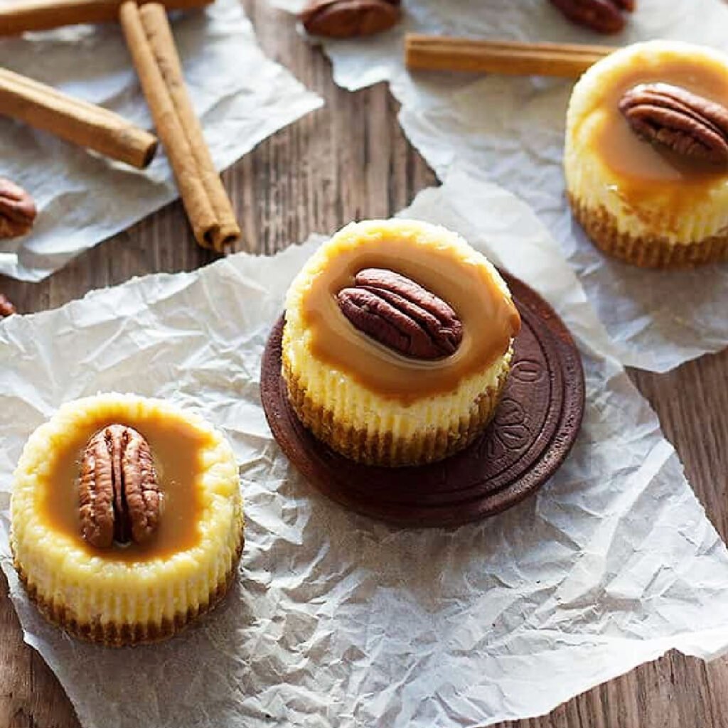 Enjoy a bite of happiness with these cute Caramel Pecan Mini Cheesecakes made in a muffin pan. They're velvety, creamy and have a perfect balance of sweetness!
