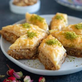 Baklava on a plate topped with nuts.