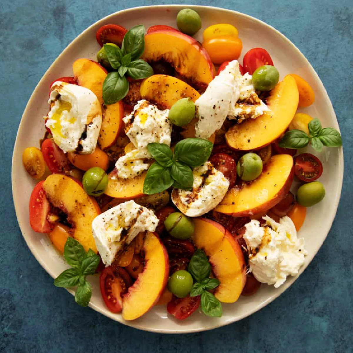Creamy burrata with tomatoes and peaches present a delightful combination of flavors, ready in just 10 minutes. I drizzle it with balsamic glaze and serve it with crusty toasted bread as a salad or an appetizer. This dish is the perfect addition to any table!
