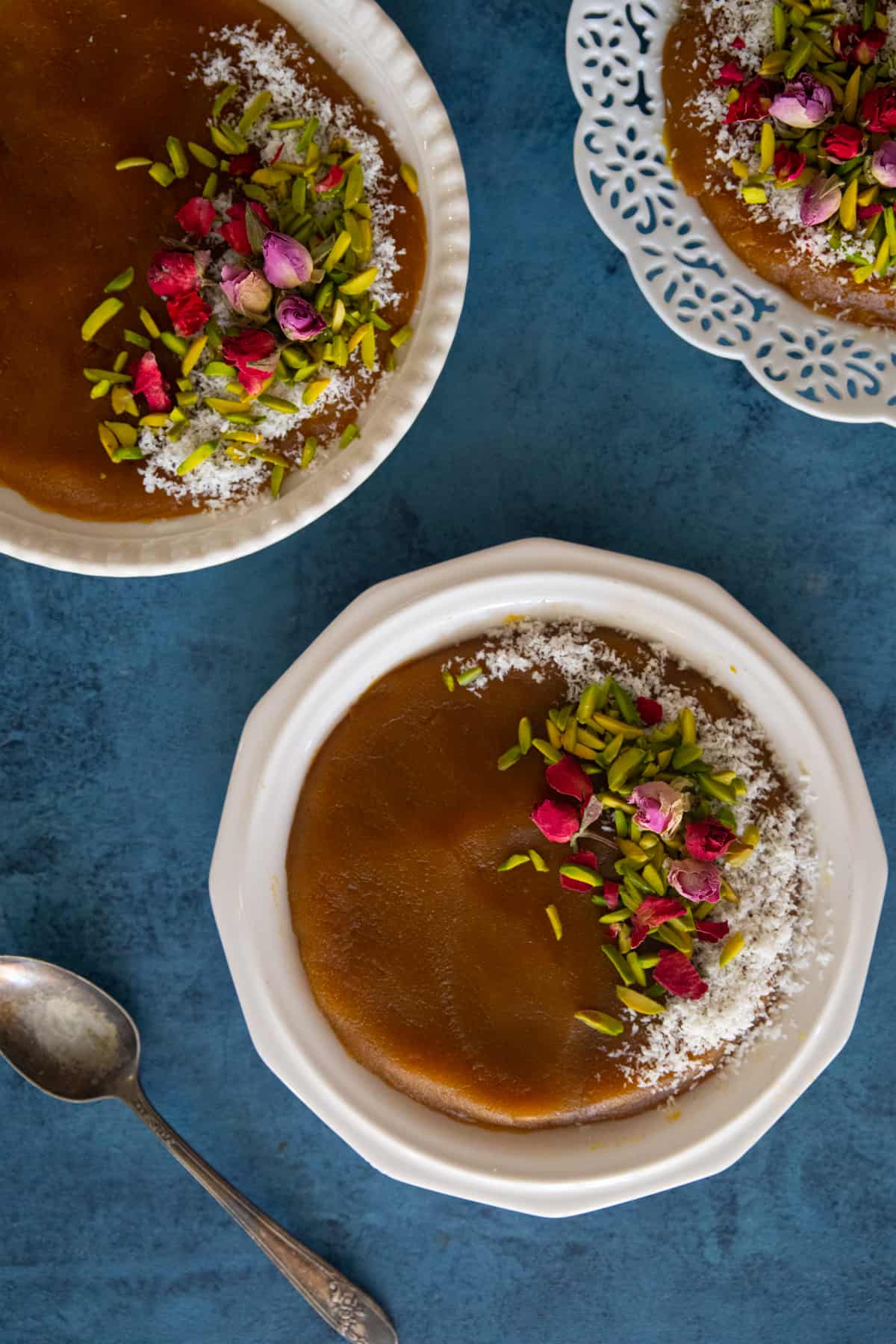 Three plates of halva on a blue backdrop. 