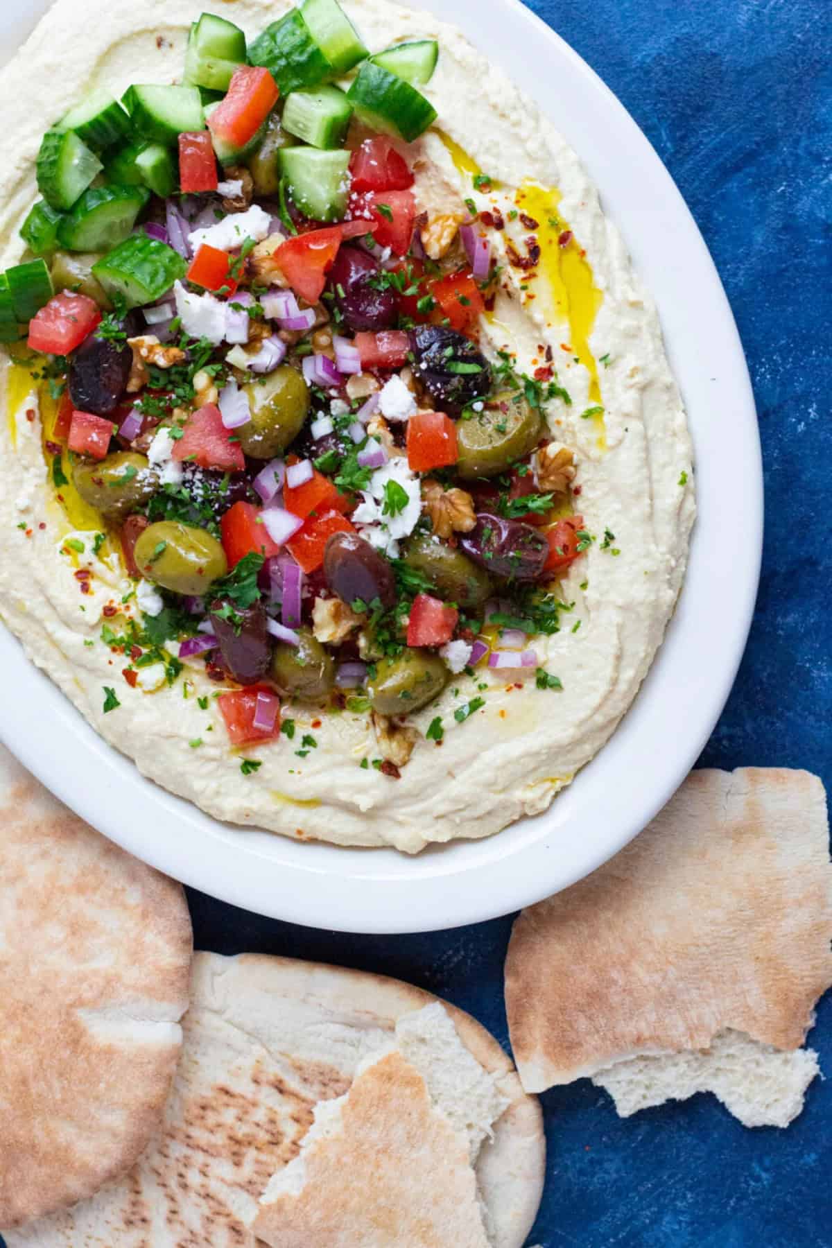 This loaded hummus recipe with all the fixings is ready in 15 minutes! Creamy hummus is topped with delicious toppings and served with pita!
