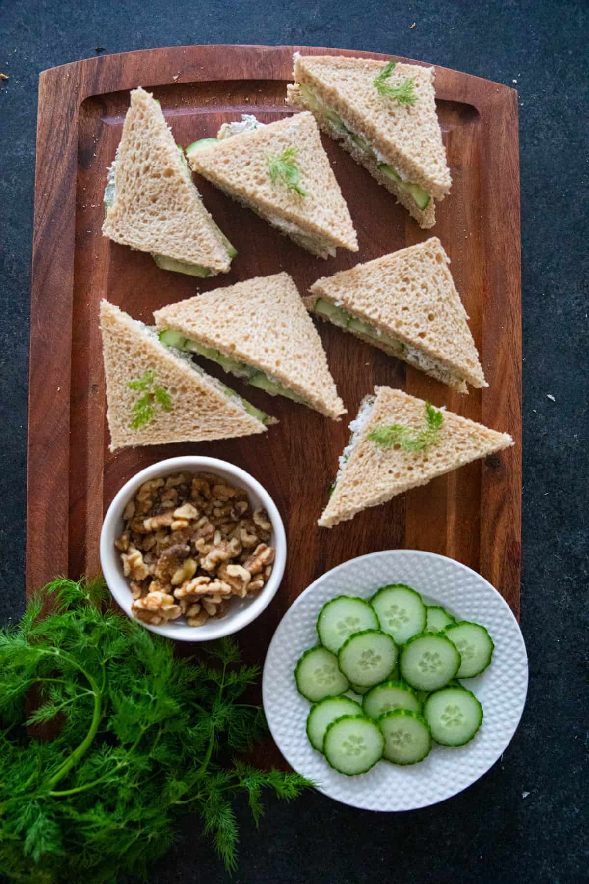 Cucumber sandwiches on a wooden board. 