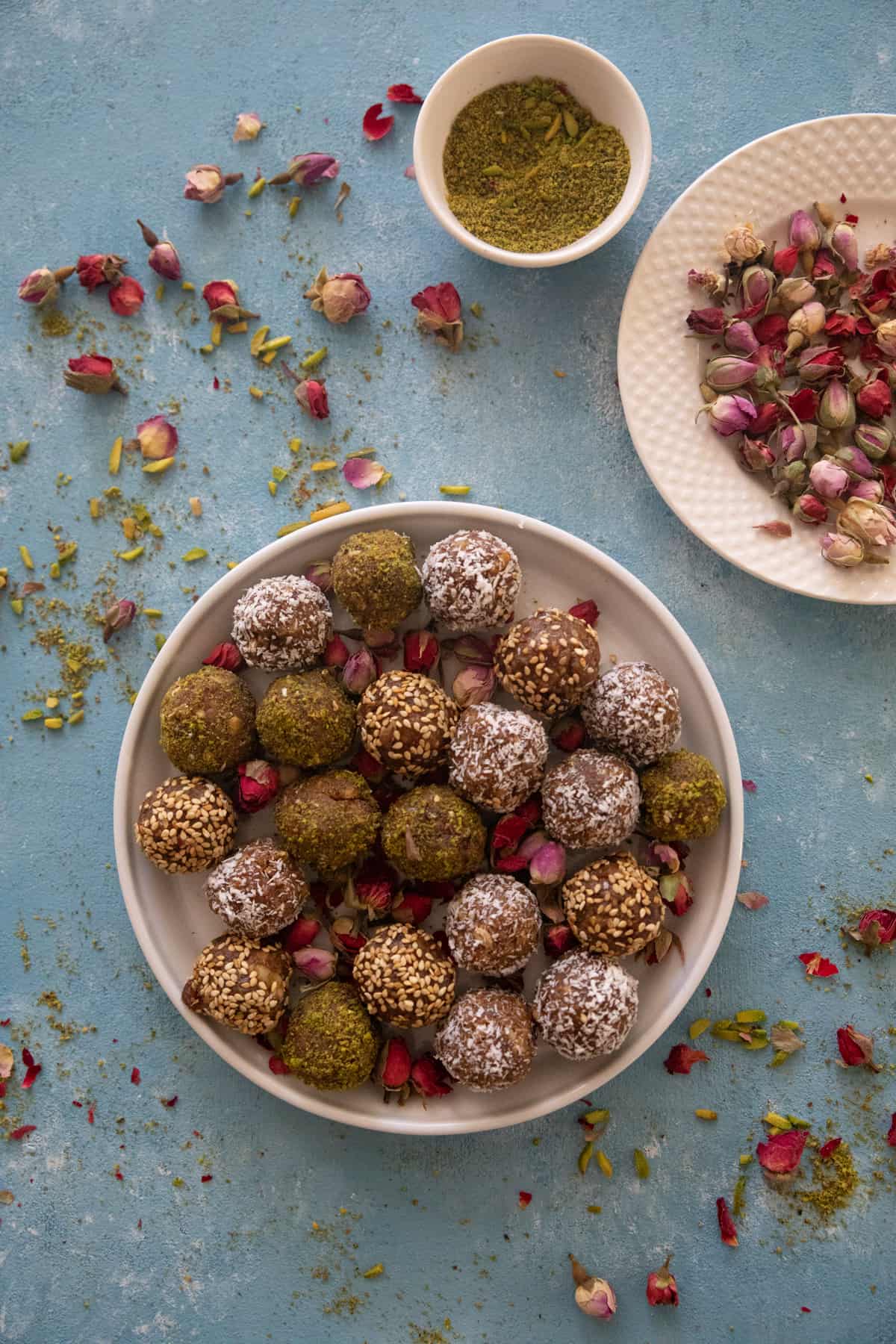 A plate of date balls on a blue backdrop. 