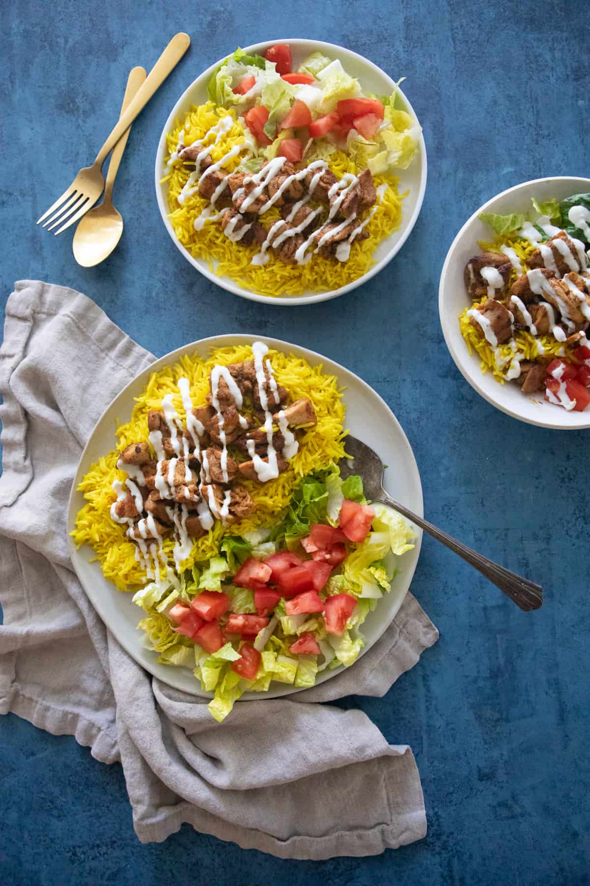 Three plates of yellow rice with chicken. 