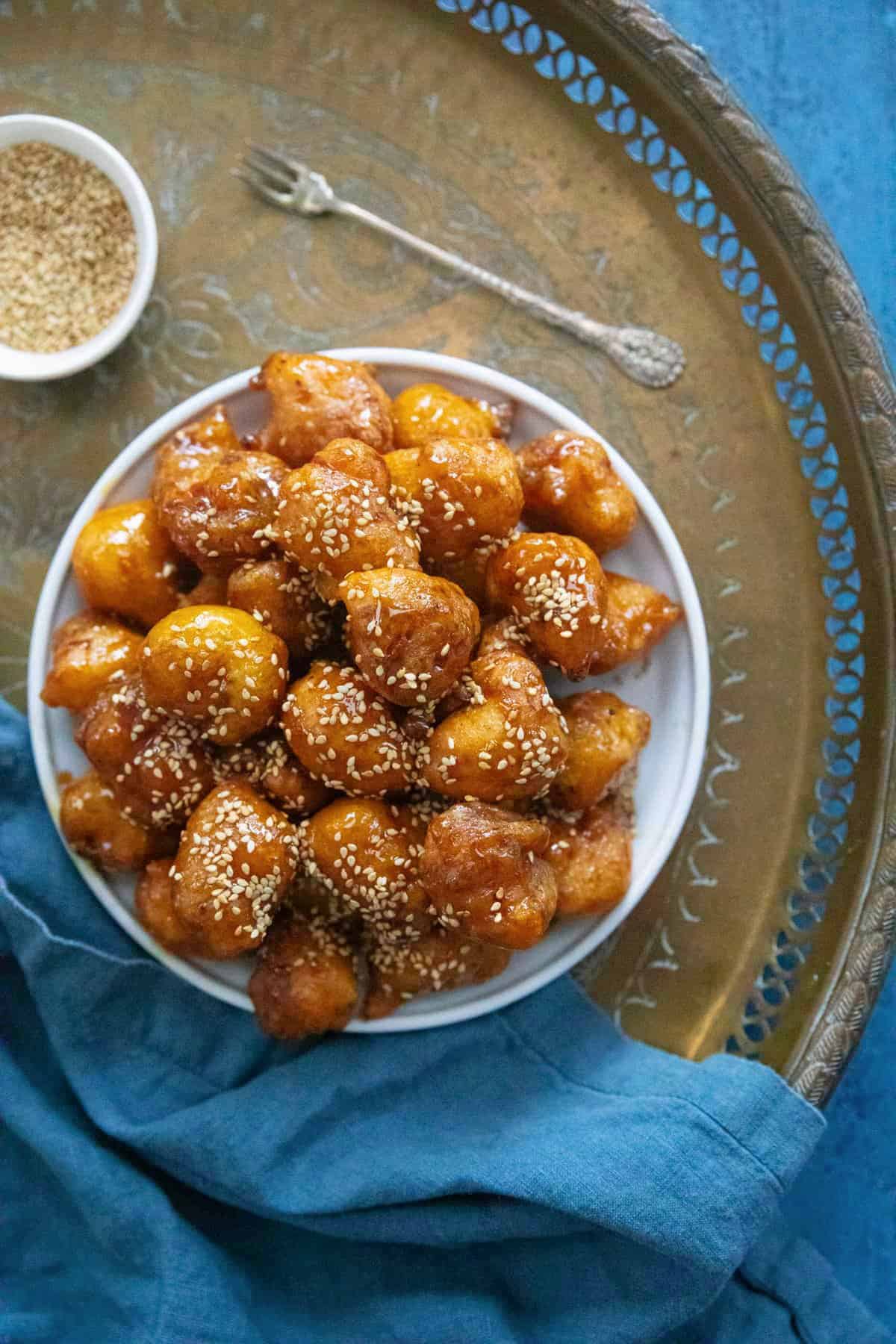 Overhead shot of Middle Eastern sweet dumplings on a tray. 