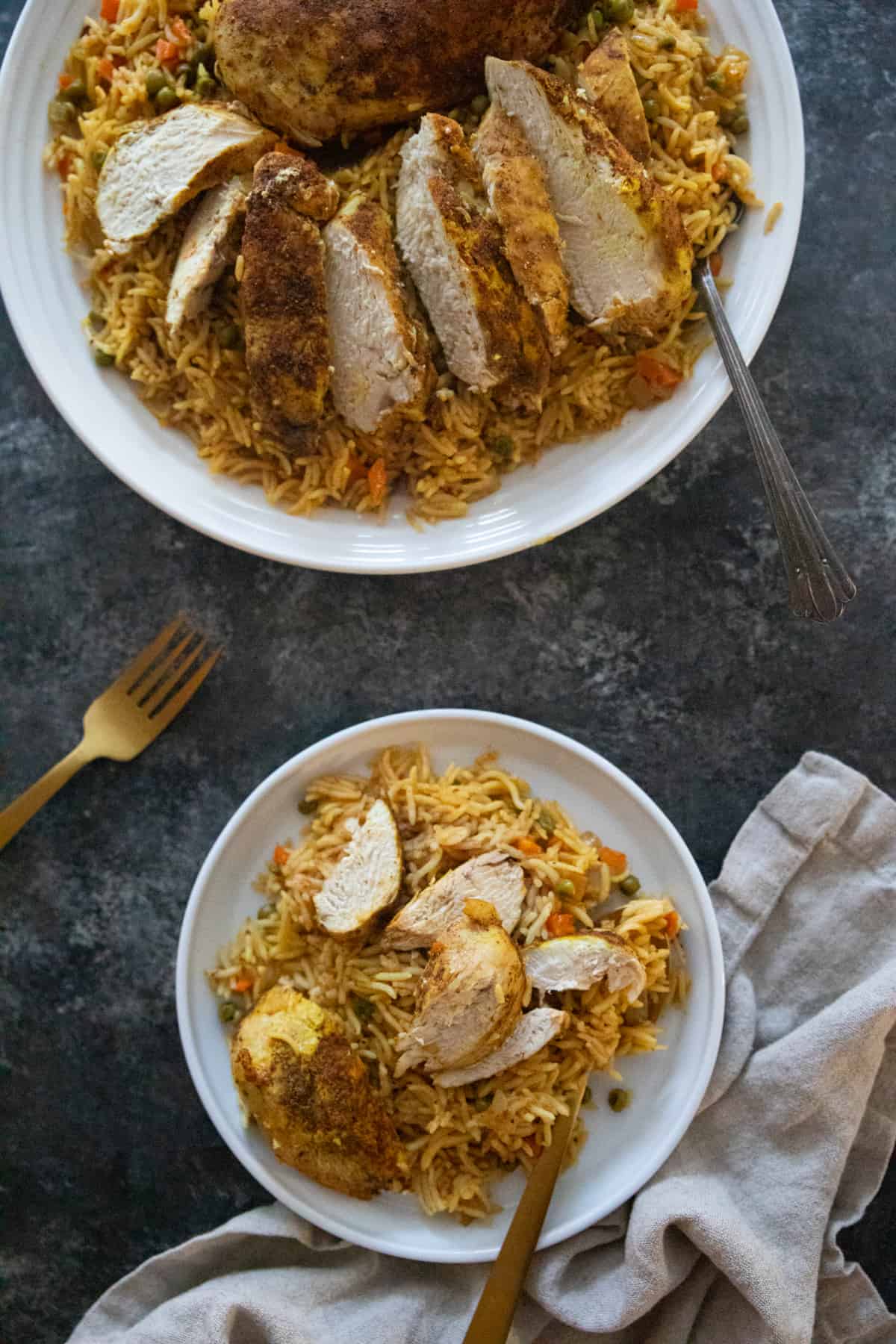 two plates of rice and chicken middle eastern style. 