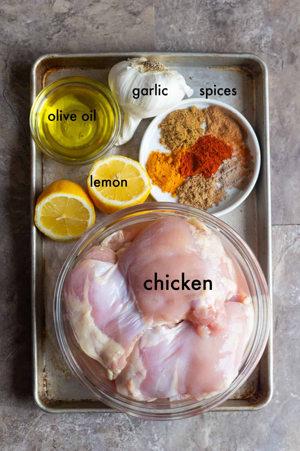 To make this recipe you need chicken thighs, a mix of spices, lemon and garlic.