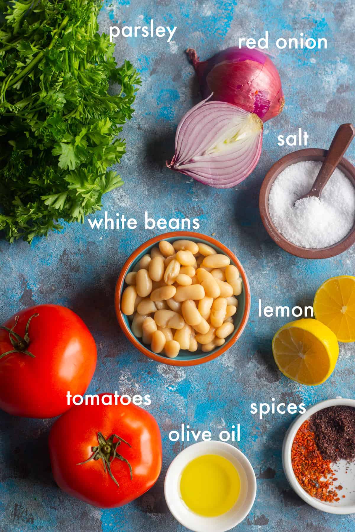 To make this salad you need white beans, parsley, red onion, tomatoes, olive oil, salt and pepper and sumac. 