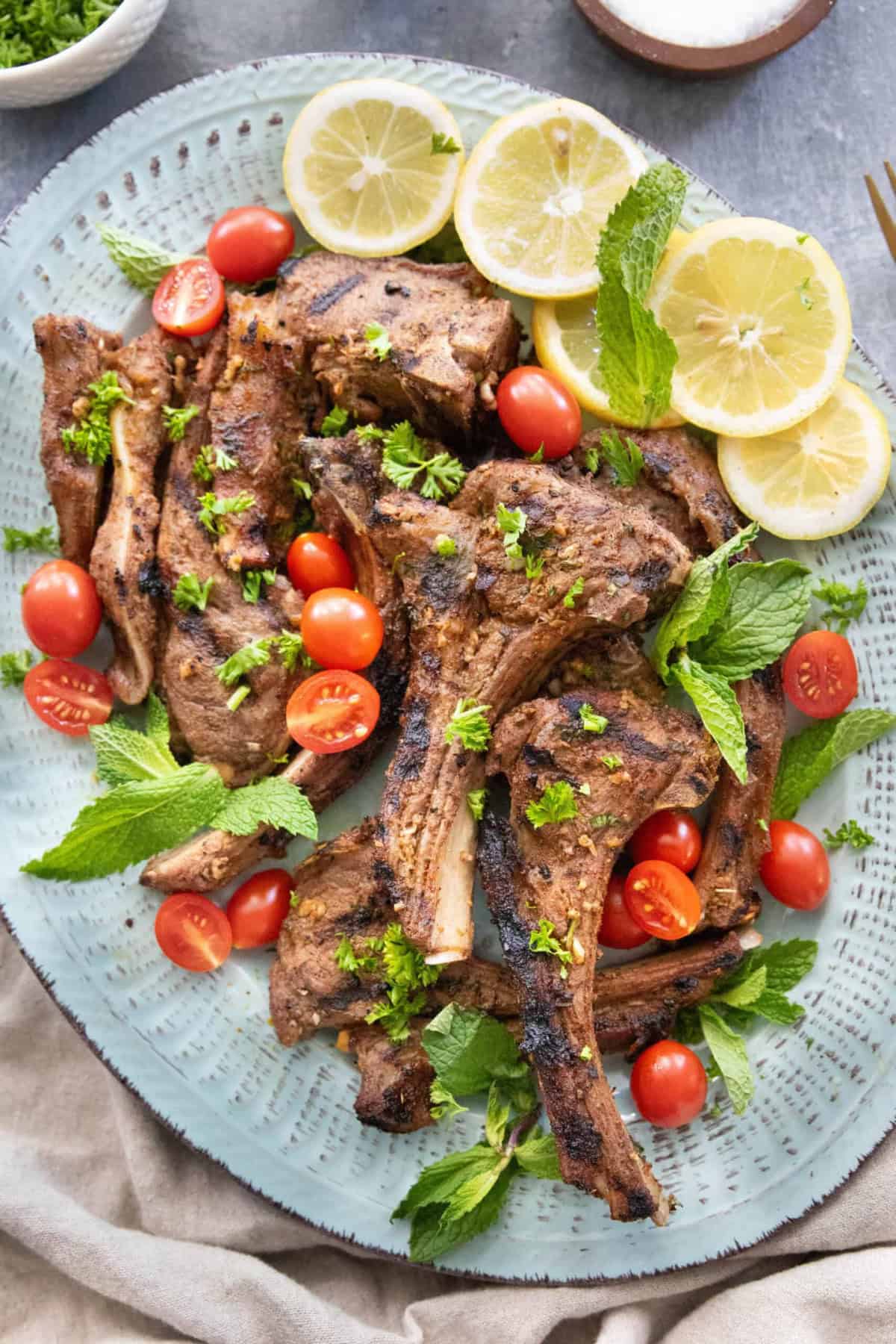 A few grilled lamb chops on a platter.