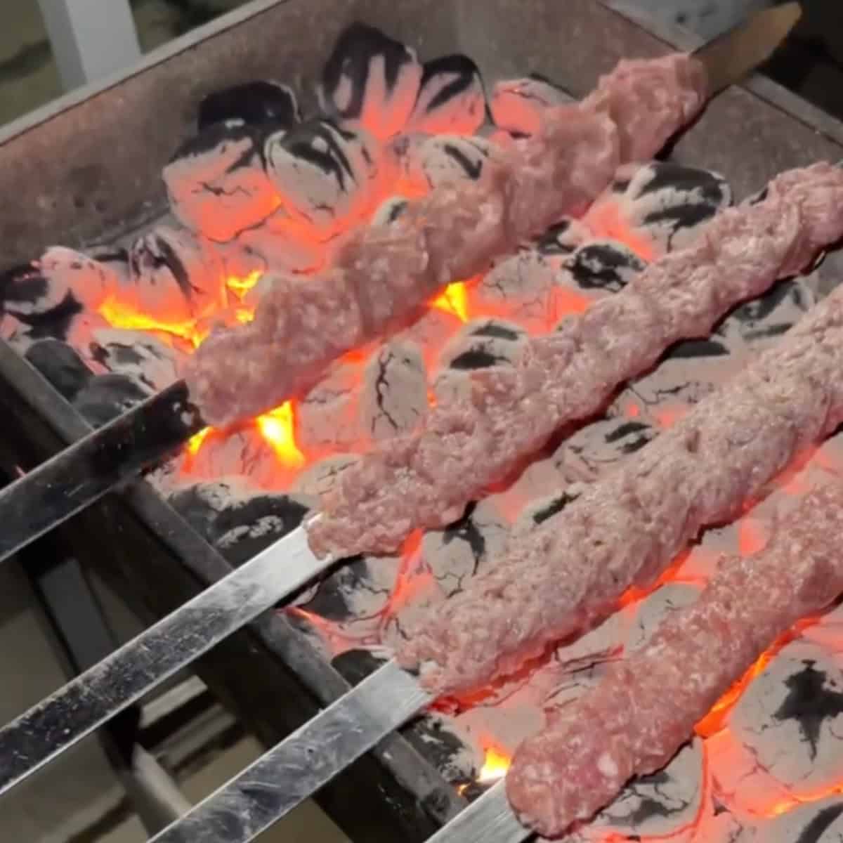 Preheat the grill until the charcoal is uniformly glowing and partially covered with ashes, or until the grill reaches a very high temperature to ensure the meat sticks to the skewers. Have a pot with a lid and some lavash nearby.