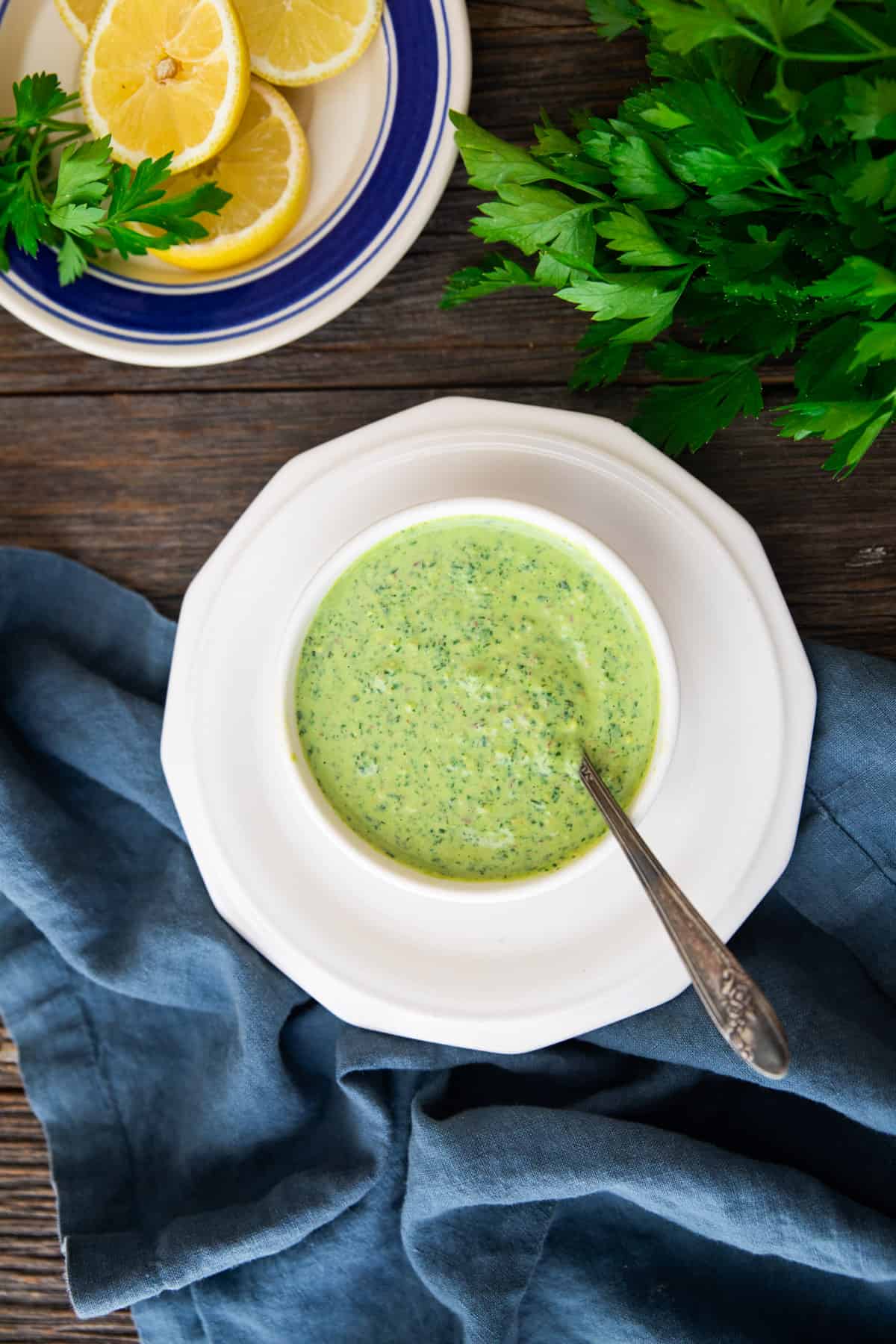 Overhead shot of green goddess dressing in a bowl on a plate. 
