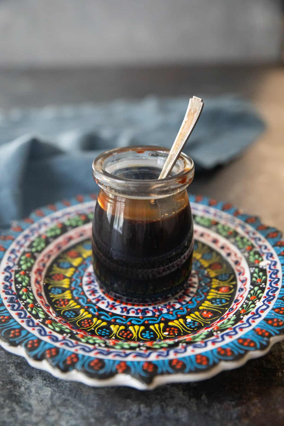A jar of pomegranate molasses on a plate. 