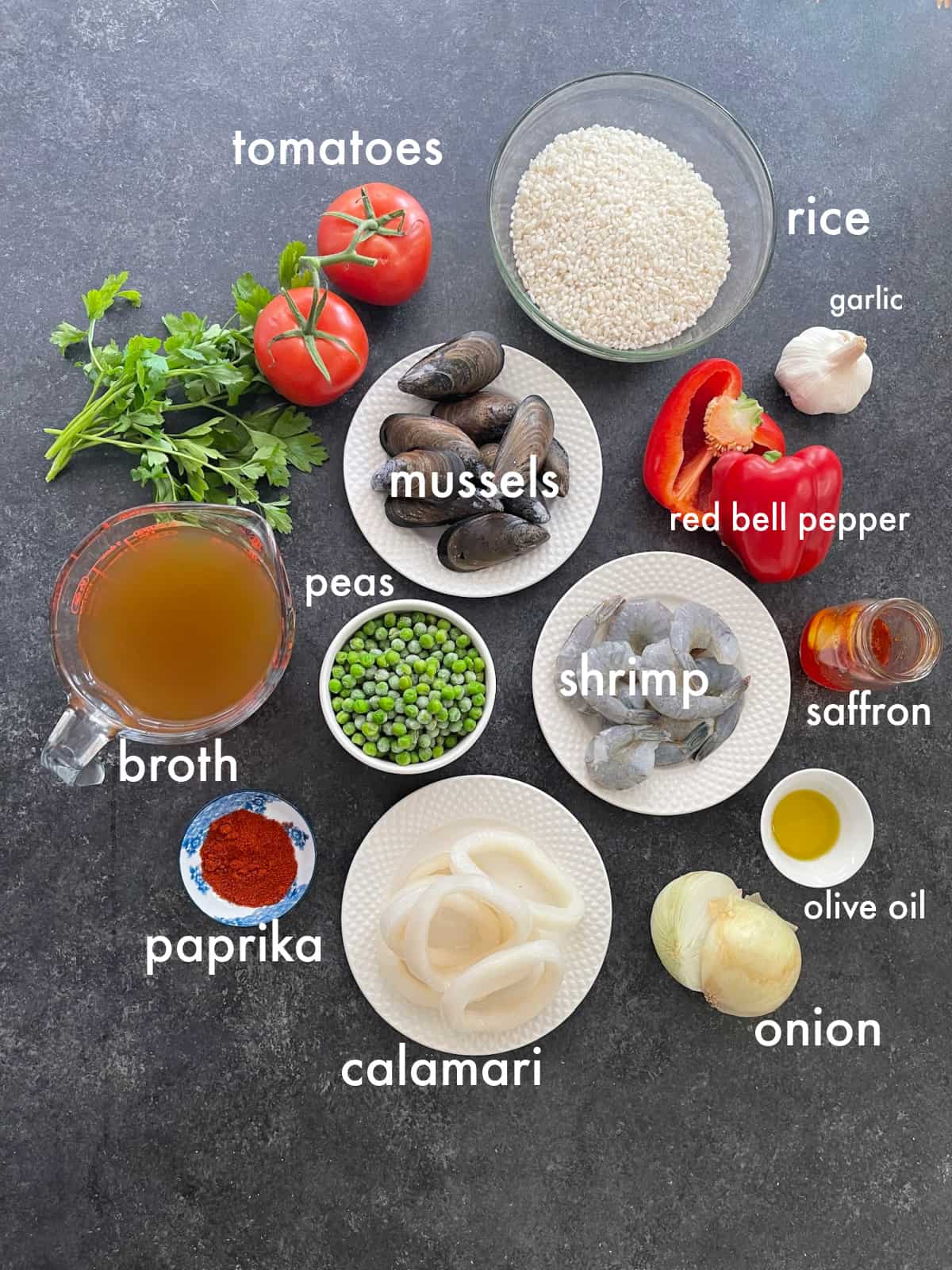 To make seafood paella you need rice, onion, garlic, tomatoes, peppers, shrimp, peas, mussels, calamari and saffron.