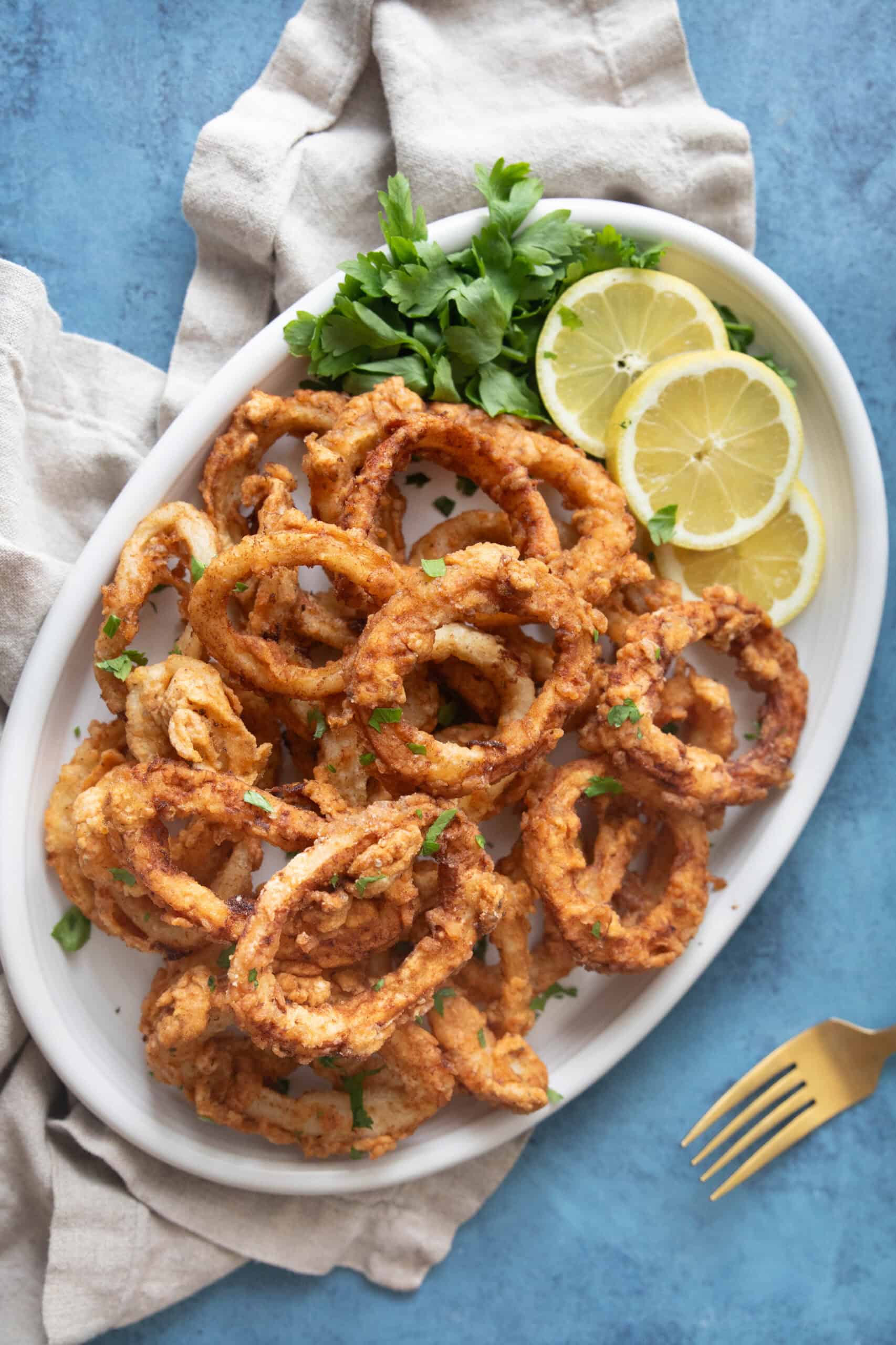 This easy fried calamari recipe will be your favorite. Calamari rings are soaked in milk to tenderize, coated in spiced flour and fried until crispy on the outside and tender on the inside. Perfection in every bite! 