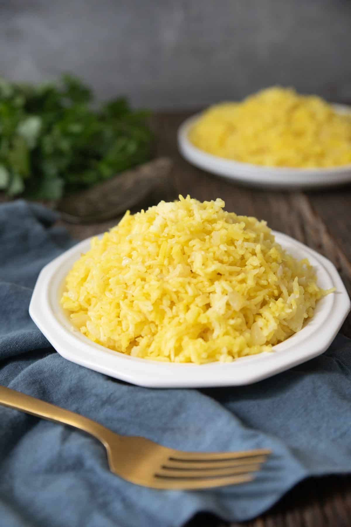 Front shot of saffron rice on a white plate. 
