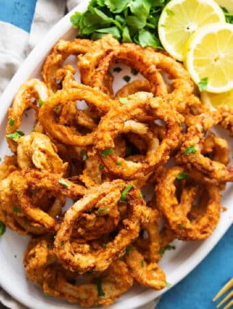 This easy fried calamari recipe will be your favorite. Calamari rings are soaked in milk to tenderize, coated in spiced flour and fried until crispy on the outside and tender on the inside. Perfection in every bite!