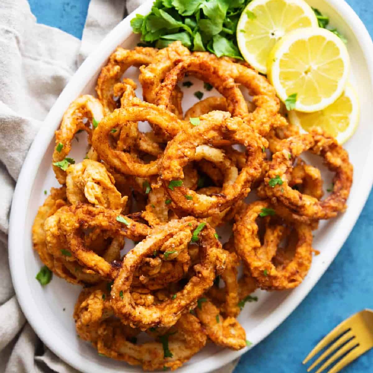 This easy fried calamari recipe will be your favorite. Calamari rings are soaked in milk to tenderize, coated in spiced flour and fried until crispy on the outside and tender on the inside. Perfection in every bite!