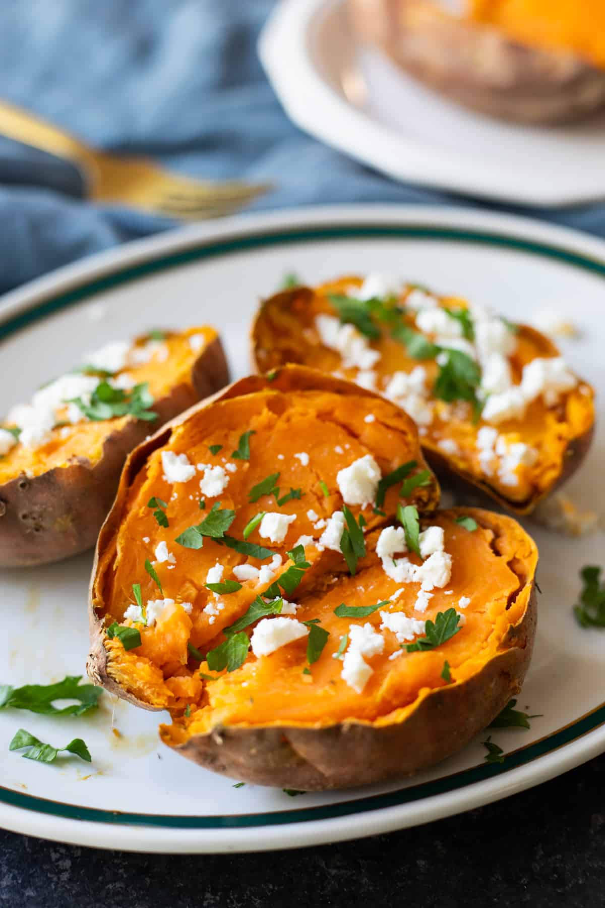 Front shot of baked sweet potatoes topped with crumbled feta. 