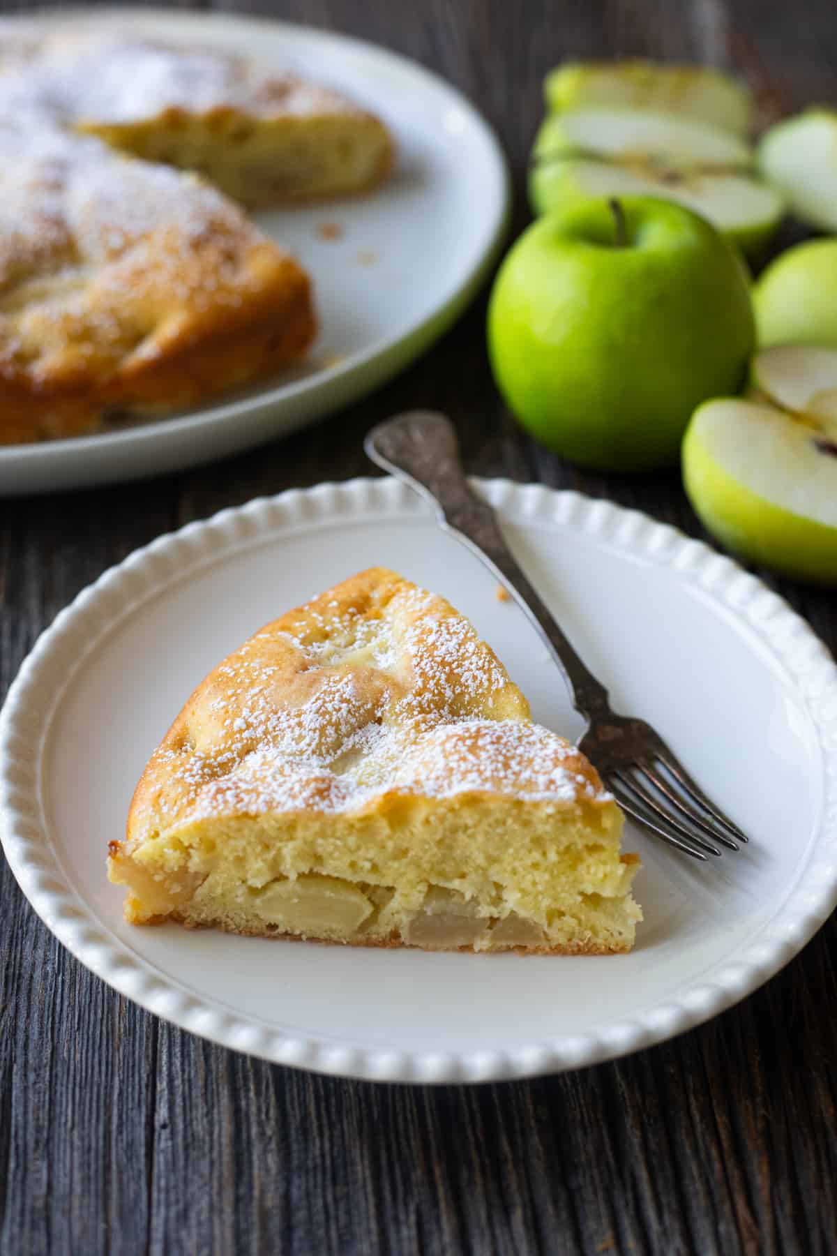 A slice of French apple cake on a plate. 