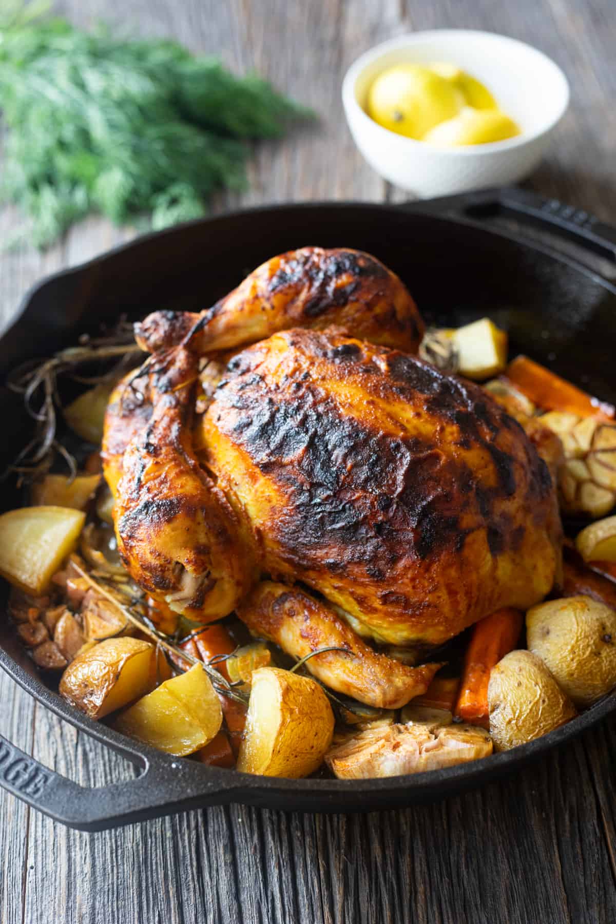Whole roasted chicken in a cast iron skillet.