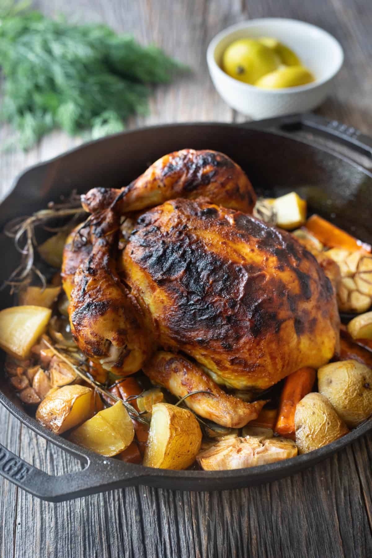 Whole roasted chicken in a cast iron skillet. 