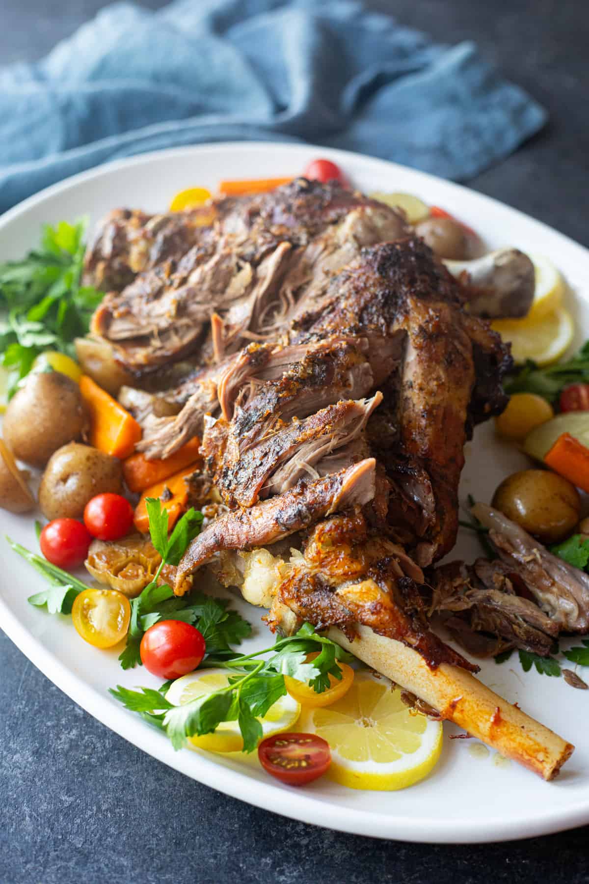 Front shot of roasted lamb leg on a platter.