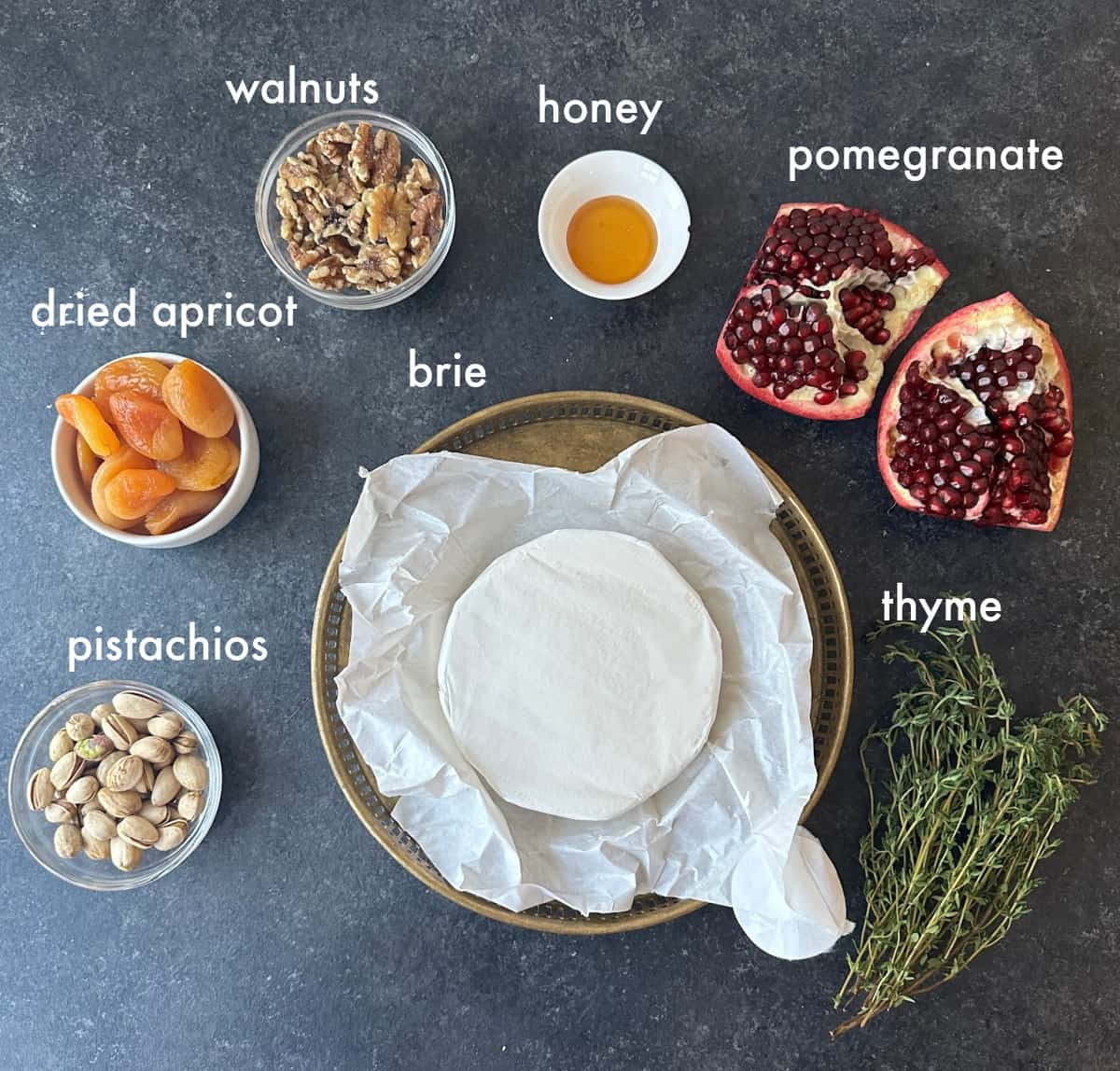 Ingredients to make baked brie you need brie, honey, dried fruit, nuts, pomegranate