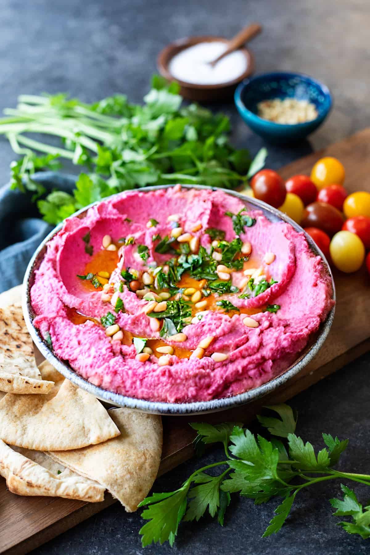 Beet hummus topped with olive oil, parsley and pine nuts. 