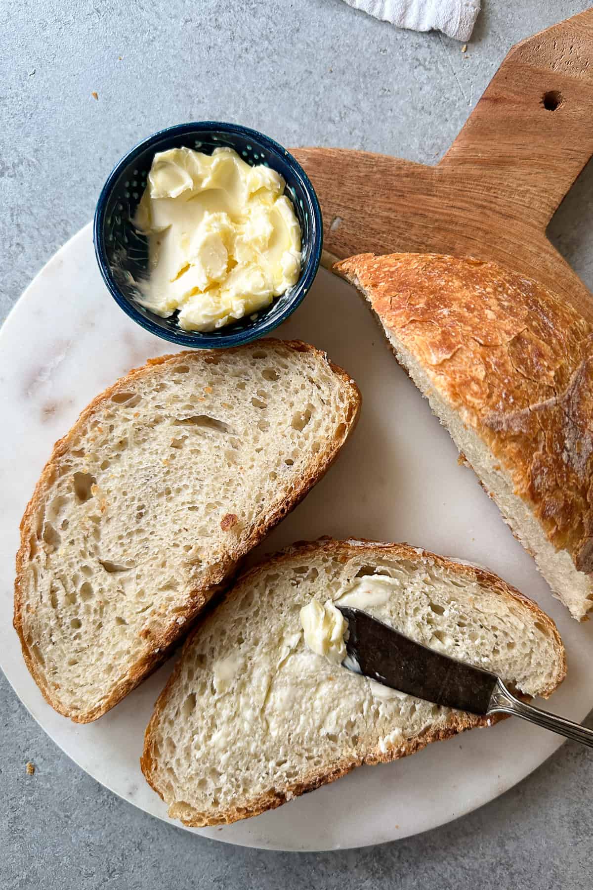 Two slices of bread topped with butter. 