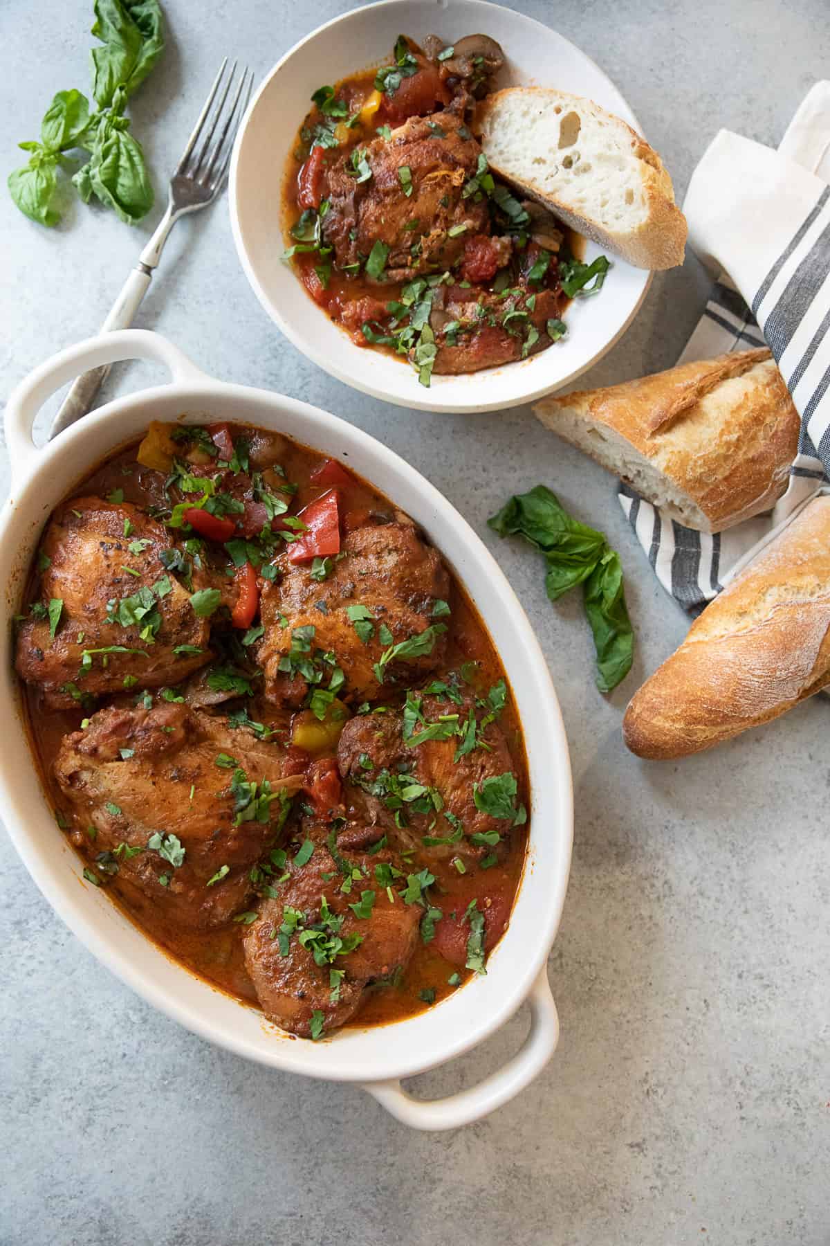 Chicken cacciatore in a serving dish on a white background.