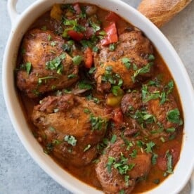 This easy chicken cacciatore recipe is a beloved Italian classic. Browned chicken is braised in a rich tomato sauce until it's tender and then served over pasta or polenta for a comforting one pot meal, perfect for a family dinner.