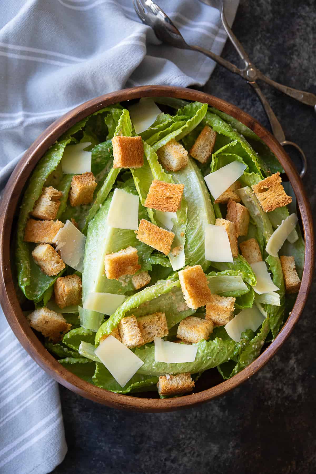 homemade Caesar salad in a wooden bowl topped with homemade croutons