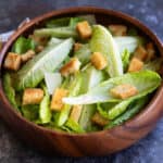 Classic Homemade Caesar Salad in a wooden bowl topped with croutons