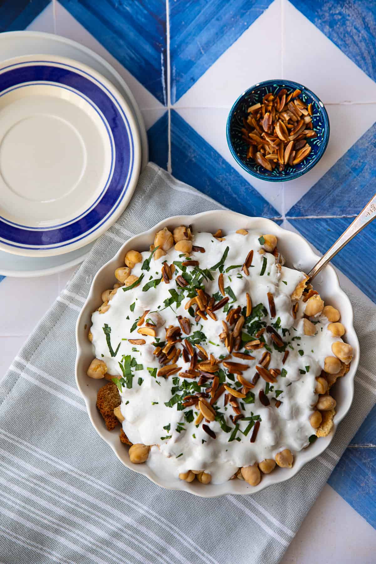 fatteh dish topped with toasted slivered almonds and garnished with fresh parsley