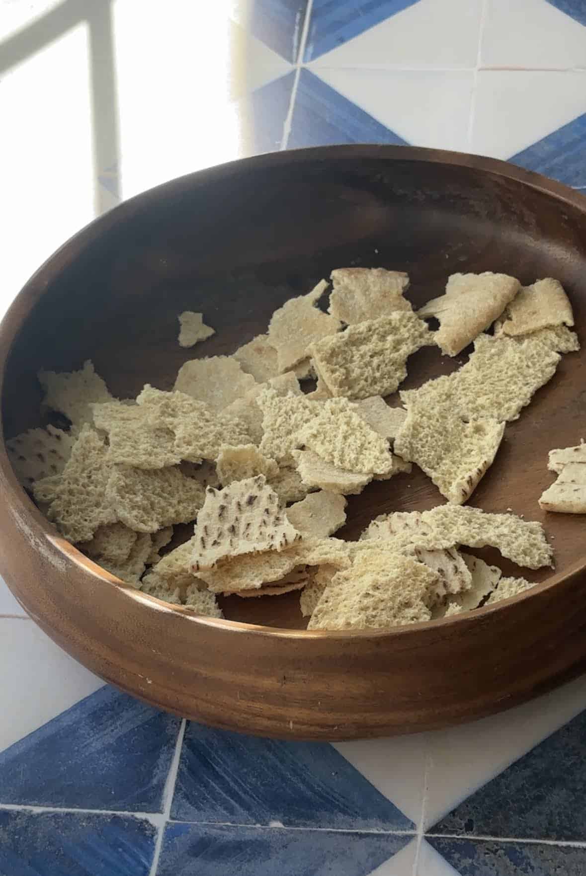 torn pieces of pita bread ready to be toasted