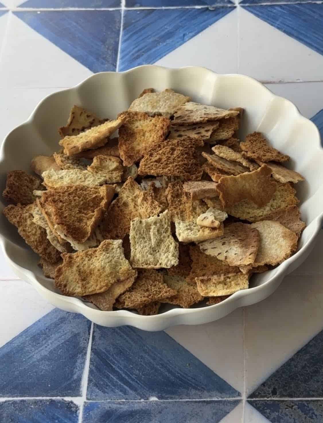 golden brown toasted pita layered in a white dish