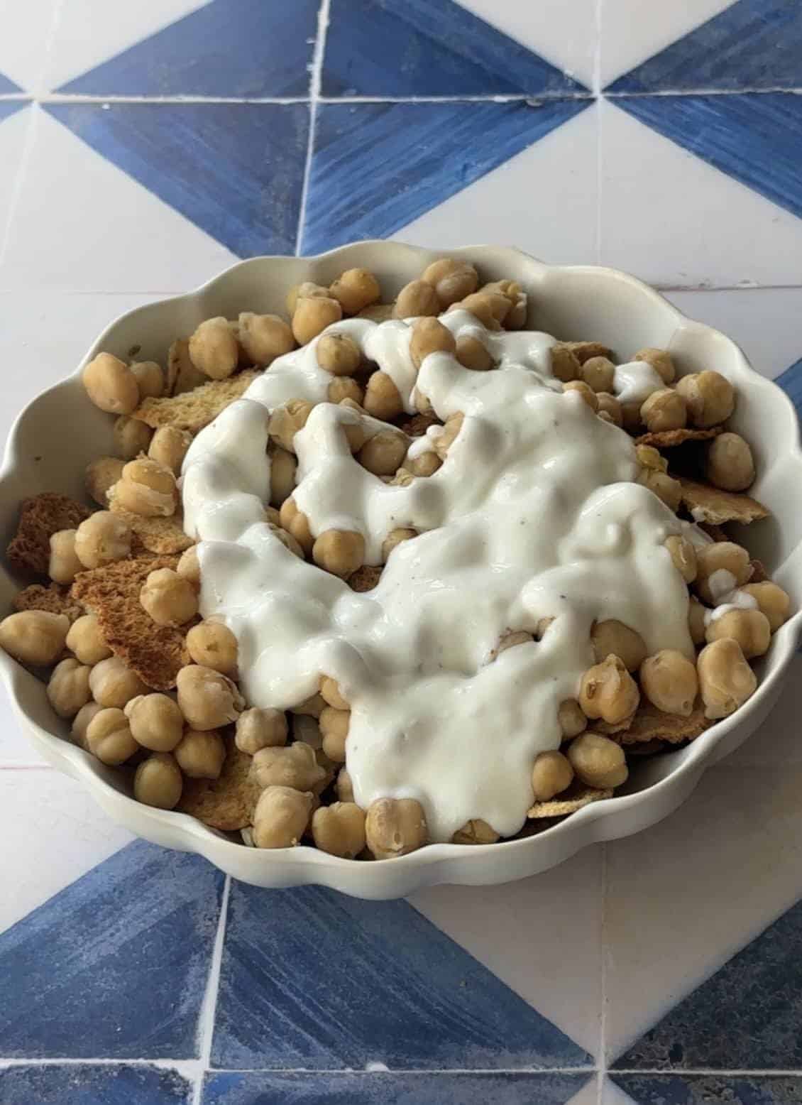 golden brown crispy pita bread topped with spiced chickpeas and drizzled with a creamy yogurt sauce